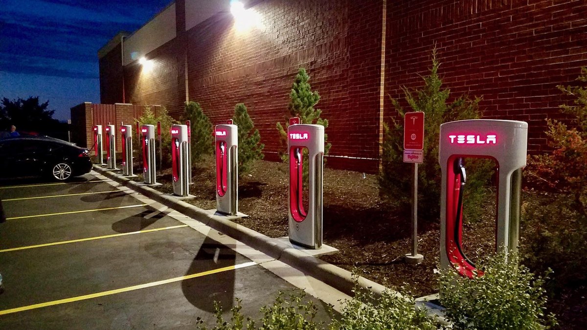 Row of Tesla Supercharger stalls at dusk