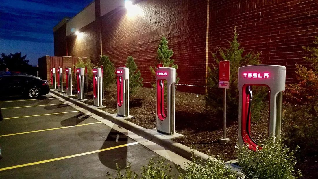 Row of Tesla Supercharger stalls at dusk